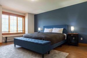 a blue bedroom with a bed and a blue wall at Pinnacle Ridge Condos by Fernie Central Reservations in Fernie