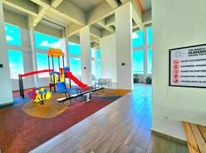 a room with a playground in a building with windows at Quartz Paragon Suites By GGM in Melaka