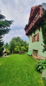budynek z zielonym dziedzińcem z ławkami i stołem w obiekcie Chata Zieleniecka w mieście Duszniki Zdrój