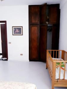 Cette chambre comprend un lit et une porte en bois. dans l'établissement Casa vacanze zina, à Altavilla Milicia