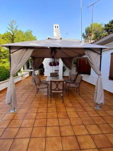 een grote tent op een patio met stoelen en een tafel bij Villa mediterránea en Roc de Sant Gaietà in Roda de Bará