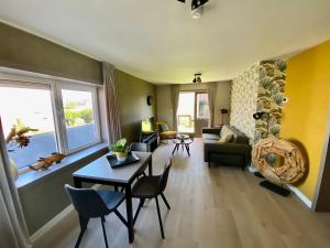 ein Wohnzimmer mit einem Sofa und einem Tisch in der Unterkunft Glücklich am Meer Meerblick mit Wellnesszugang in Egmond aan Zee