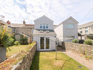 a white house with a stone wall at Boslow in St. Just