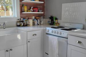 a white kitchen with a stove and a sink at Surprisingly Styish Stays in Hoquiam