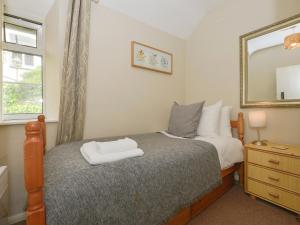 a bedroom with a bed with a mirror on the wall at Woodedge in Minehead