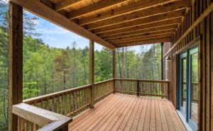 um deque de madeira com vista para os bosques em Cabin Coco - June sale dates! Luxe A Frame with projector screen, arcade and swim spa em Sevierville