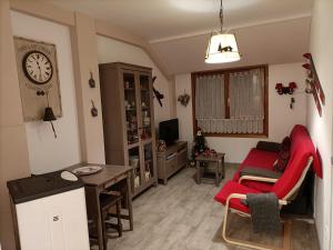 a living room with a red couch and a table at Apartamento Arañones in Canfranc-Estación