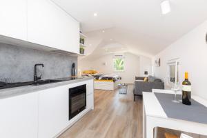 a kitchen and living room with white cabinets at Easy in Mali Lošinj