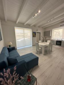 a living room with a blue couch and a table at Rachele Boutique Apartments in Agropoli