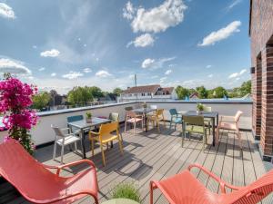 a patio with tables and chairs on a roof at Gästehaus linda&otto in Achim