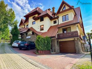 une maison avec une voiture garée devant elle dans l'établissement Willa Michałówka, à Zakopane