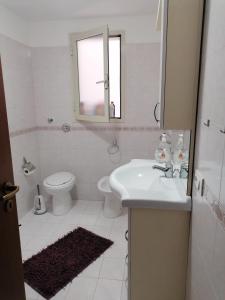 ein Badezimmer mit einem Waschbecken, einem WC und einem Spiegel in der Unterkunft Tulipano in Trapani