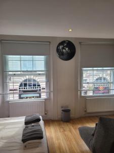 um quarto com uma cama e duas janelas com um relógio lunar em 3 Bedroom Apartment in Central London Sleep 10 HY2 em Londres