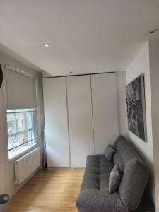 uma sala de estar com um sofá e uma grande janela em 3 Bedroom Apartment in Central London Sleep 10 HY2 em Londres