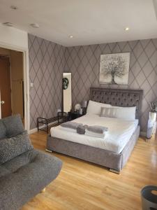 een slaapkamer met een groot bed en een bank bij 3 Bedroom Apartment in Central London Sleep 10 HY2 in Londen