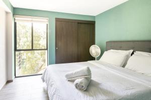 Un dormitorio con una cama con una toalla. en Amazing 2BR view to Parque España in Condesa, en Ciudad de México