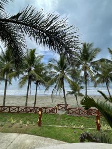 LalauiganにあるLa Playita Resortの椰子の木と木の柵のある浜