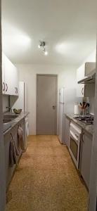 La cuisine est équipée de placards blancs et d'un four avec plaques de cuisson. dans l'établissement Casa du voyage, à Boquilla