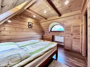 ein Schlafzimmer mit einem Bett in einem Holzzimmer in der Unterkunft Bartusiowa Osada in Zakopane