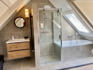 a bathroom with a shower and a sink at Glücklich am Meer Apartment Meerblick in Egmond aan Zee +39 photos
