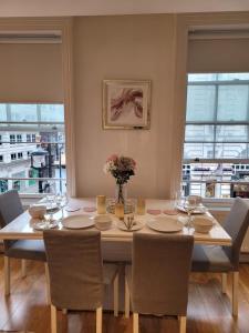 uma mesa de jantar com cadeiras e uma grande janela em 3 Bedroom Apartment in Central London Sleep 10 HY2 em Londres