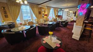 um restaurante com mesas e cadeiras e um bar em NELSON Hotel em Great Yarmouth