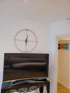 a clock on a white wall above a piano at 3 Bedroom Apartment in Central London Sleep 10 HY2 in London