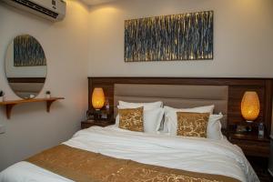 a bedroom with a bed with two lamps and a mirror at صالة وغرفتين نوم دخـول ذاتي in Al Kharj