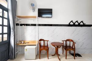 eine Küche mit 2 Stühlen, einem Tisch und einem TV in der Unterkunft Lam Sơn Hotel in Ho-Chi-Minh-Stadt
