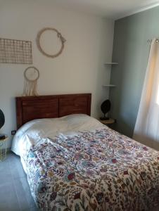 Un dormitorio con una cama con una manta de flores. en Couleur pastel en Saint-Louis