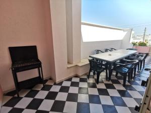 een kamer met een tafel en stoelen op een geruite vloer bij casa rosa in Tiggiano