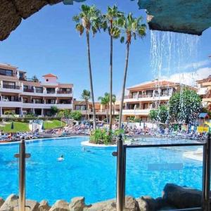 una piscina con palme in un resort di Apartamento Albatros Golf del Sur Apt 257 a San Miguel de Abona