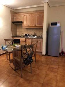una cucina con tavolo e frigorifero in acciaio inossidabile di Apartamento Albatros Golf del Sur Apt 257 a San Miguel de Abona