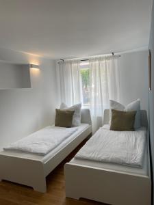 2 camas en una habitación blanca con ventana en Hugo Inn 2, en Stockach