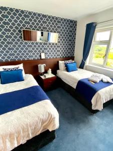 a bedroom with two beds and a mirror on the wall at Cullentra House in Cushendall