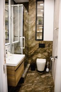 een badkamer met een wastafel, een toilet en een douche bij Апартаменты в ЖК Шоколад in Alma-Ata