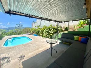 a patio with a pool and a table and a couch at Casa Johanna, Charm and Tranquillity ! in Atenas