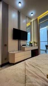 een slaapkamer met een groot bed en een flatscreen-tv bij Апартаменты в ЖК Шоколад in Alma-Ata
