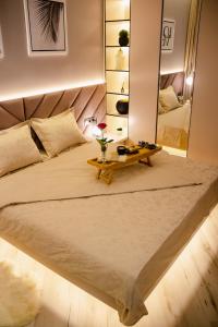 1 dormitorio con 1 cama grande y espejo en Апартаменты в ЖК Шоколад, en Almaty