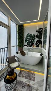 Habitación con baño con bañera y silla. en Апартаменты в ЖК Шоколад, en Almaty