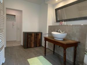 ein Badezimmer mit einem Waschbecken auf einem Holztisch in der Unterkunft Fischbach Apartment in Saarbrücken