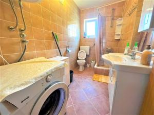 a bathroom with a washing machine and a sink at Apartments Višić in Gornji Karin +30 photos