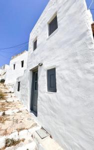 a white building with a door on the side of it at Castle seaview retreat in Alona
