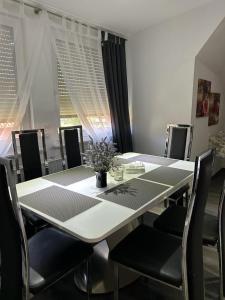 uma sala de jantar com uma mesa branca e cadeiras em Wolfenbüttler Apartment em Volfembutel