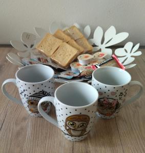 a group of three coffee cups and a plate of food at In viaggio con Pippo - Ampio appartamento con AC nei pressi di Piazza Bovio e del Rivellino in Piombino