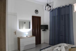 a bedroom with a bed and a blue shower curtain at Casa Nonna Nina in Trabia