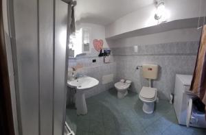 y baño con lavabo blanco y aseo. en Monolocale in via pedonale, en Saint Vincent