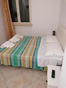 1 cama con sábanas blancas y almohadas en una habitación en Casa Vacanze Paiano, en Casamassella