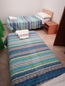 CasamassellaにあるCasa Vacanze Paianoのベッド2台とカラフルな毛布が備わる客室です。