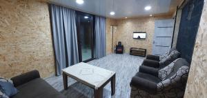- un salon avec un canapé, une table et une télévision dans l'établissement Afrodita Hotel, à Stepanavan